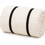 Undyed organic cotton sleeping bag rolled up and secured with two black straps