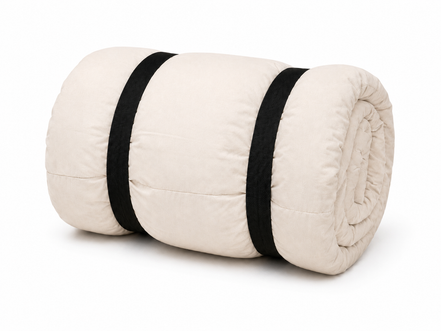 Undyed junior organic cotton sleeping bag rolled up with two black straps